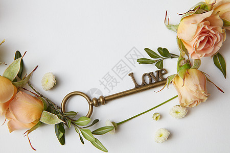 带玫瑰的框架白色背景上的钥匙,文字的带玫瑰花瓣的钥匙图片