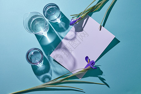 美丽的框架与新鲜的紫罗兰花阴影璃透明花瓶蓝色背景与妇女节平躺春天成的璃花瓶紫色的花蓝色的背景图片