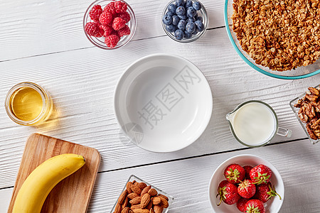 空盘子,机麦片,香蕉,蜂蜜,牛奶,浆果杏仁个白色的木制桌子上,健康早餐的配料,步的食谱的风景图片
