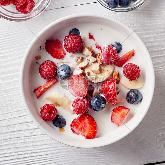 白色桌子上的白色陶瓷碗的特写,天然的机成分,用于天然健康的早餐自然清洁饮食的平躺谷类食品香蕉切片,草莓,图片