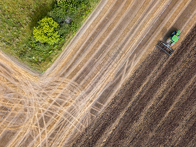 为播种工程准备农业区,收获后用拖拉机种植土壤无人机上看的鸟瞰夏天用拖拉机耕地收割后的农田的风景图片