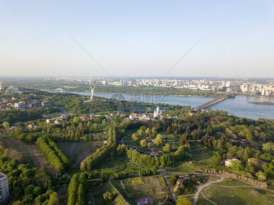 无人机鸟瞰基辅聂伯河的历史名胜,以及夏季日落时拥现代建筑的城市左岸鸟瞰,无人机植物园祖国纪念碑聂伯河图片