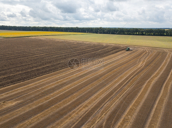 秋天的时候,田野上收获后犁地的全景收获后田野的无人机上俯瞰片望无际的农田,夏天的天里,用拖拉机收割,图片