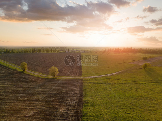 无人机的全景,空中摄影的景观与农业领域准备播种多云的天空背景下,日落的绿色黑色无人机的空中视图,鸟瞰抽象的几何形式的图片