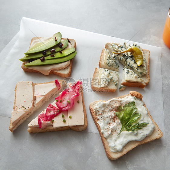 三明治片与奶酪蔬菜羊皮纸上的混凝土背景同类型的吐司图片