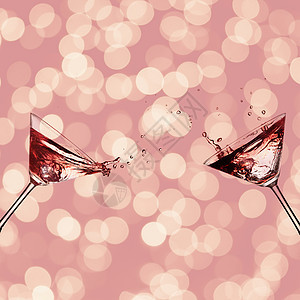 两杯鸡尾酒,马提尼,溅粉红色背景上两杯鸡尾酒图片