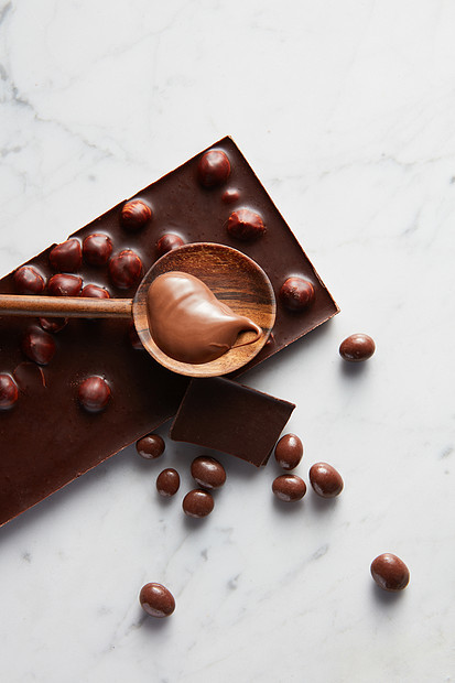 巧克力棒上焦糖的木制勺子白色的巧克力球带巧克力的木勺子图片
