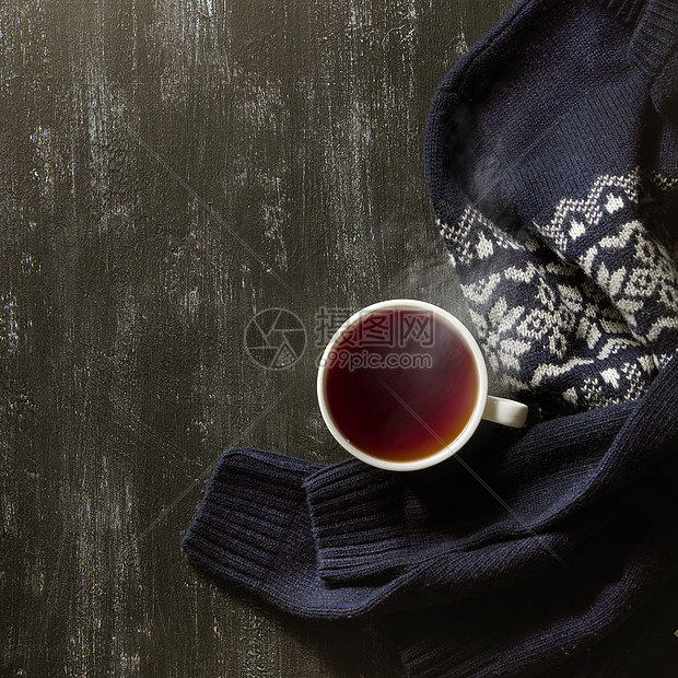 舒适的冬季家居背景,杯热茶温暖的针毛衣黑色背景舒适的冬季家居背景图片