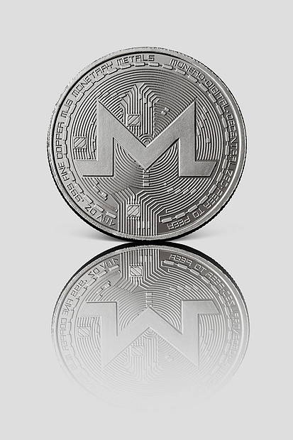 银币Monero白色光泽的背景上反射世界范围内加密货币数字支付系统的图像白色光泽背景上的银币Monero图片