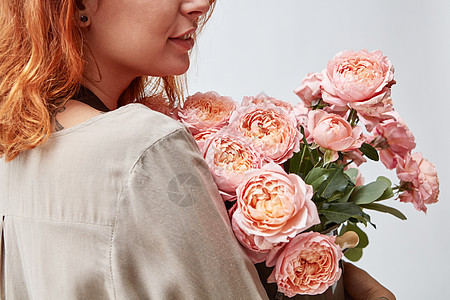 美丽的轻女孩,花瓶里粉红色的玫瑰母亲节女人着个花瓶新鲜的粉红色玫瑰图片