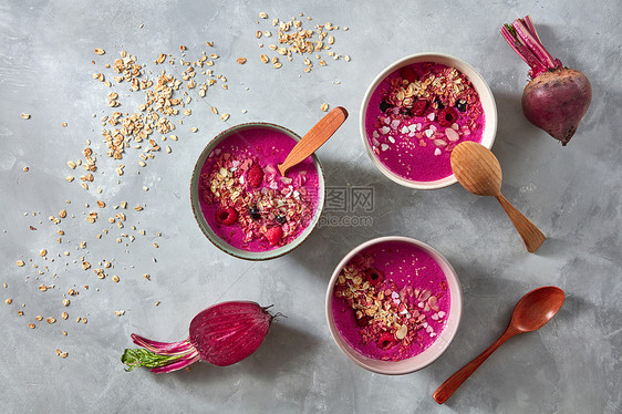 超级食物红色冰沙碗与甜菜根,燕麦片覆盆子石头背景,平躺健康早餐碗与甜菜根,燕麦片浆果石头背景,平躺图片