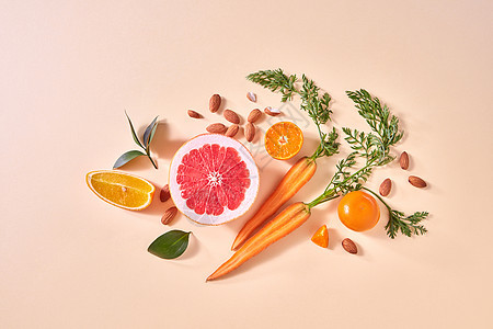 天然机柑橘类水果蔬菜黄纸背景下制作自制排冰沙的原料,平躺胡萝卜,橘子片柚子片,曼达林,杏仁,绿叶图片