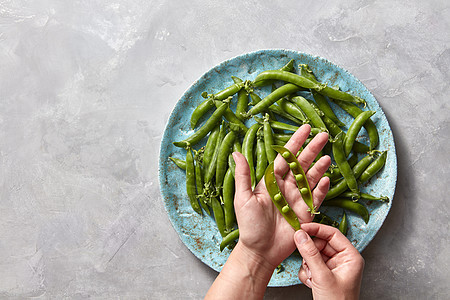 新鲜采摘的绿色蔬菜烹饪天然健康食品灰色大理石厨房桌子上与地方FOT文本顶部视图梨棒蓝色陶瓷板上的灰色混凝土桌子上的豌豆图片