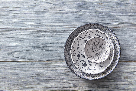 瓷灰色的碗盘子灰色的木桌上,文字的地方五颜六色的陶瓷复古手工菜肴平躺装饰陶器碗,盘子覆盖着灰色的木制背景图片