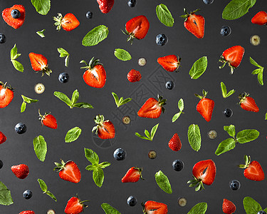 黑色背景上分离出草莓红熟蓝莓绿色薄荷枝的彩色成分的顶部视图平躺的水果图案与草莓,蓝莓薄荷叶黑色的背景图片