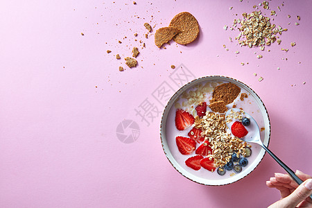 健康的冰沙白色碗与天然水果,燕麦片饼干与妇女的手勺子粉红色的背景超级食物,自然排,饮食健康食品的风景图片