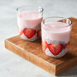 健康的粉红色冰沙眼镜与天然水果草莓辣椒种子木斯德灰色背景超级食物,自然排,饮食健康食品机酸奶奶昔与草莓辣图片
