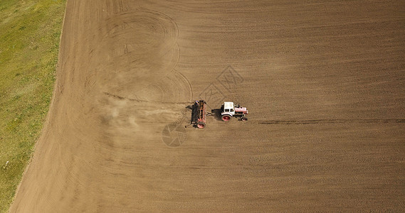 带拖车的工作拖拉机农田上的鸟瞰图农业的工业背景无人机的照片拖拉机割草棕色田地的鸟瞰图图片