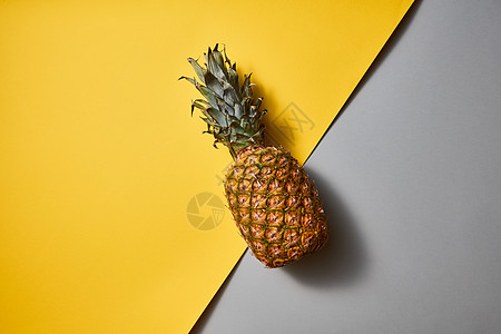 该成分与中央放置的热带异国水果单菠萝双酮黄灰色角线背景平躺的热带菠萝水果单双酮黄灰色背景图片