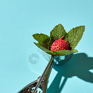 创意构图荔枝水果与薄荷叶金属勺子冰淇淋蓝色璃背景与阴影食物现代风格冰淇淋的勺子与荔枝水果薄荷叶蓝色的背景与硬阴图片