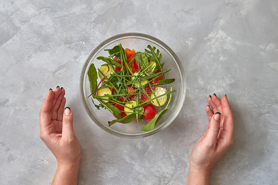 新鲜蔬菜沙拉女的手着个盘子,背景灰色的沙拉张来自系列逐步准备沙拉的照片健康的食物俯视图,平躺新鲜图片