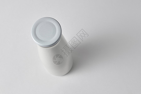 顶部视图的封闭瓶与新鲜牛奶白色背景与白色背景上新鲜牛奶的瓶子的顶部视图图片