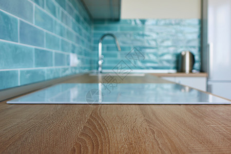个现代厨房里,个棕色的厨房台上个白色的滚刀个蓝色的瓷砖用白色滚刀观看厨房棕色台图片
