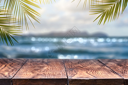 景观景观与旧木桌椰子叶模糊的蓝海白沙滩与清晰的蓝天背景夏季放松聚会海滩模糊背景与棕榈叶背景与老式旧木桌图片