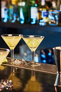 酒吧的桌子上,两杯冷鲜鸡尾酒,片石灰酒吧里美味的鸡尾酒背景图片