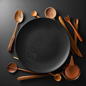 黑桌上空黑盘木勺叉子刀空盘木制餐具图片