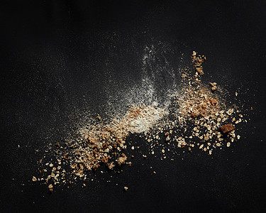 包屑与粉代表黑色背景厨房的顶部视图黑色桌子包屑粉经过烘焙烹饪新鲜包食品工业的背景上洒粉图片