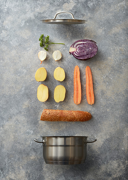 打开平底锅切片蔬菜烹饪与袋灰色混凝土背景,平躺平底锅汤的配料图片