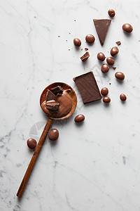 白色大理石背景上巧克力巧克力球的木制勺子带巧克力的木勺子图片
