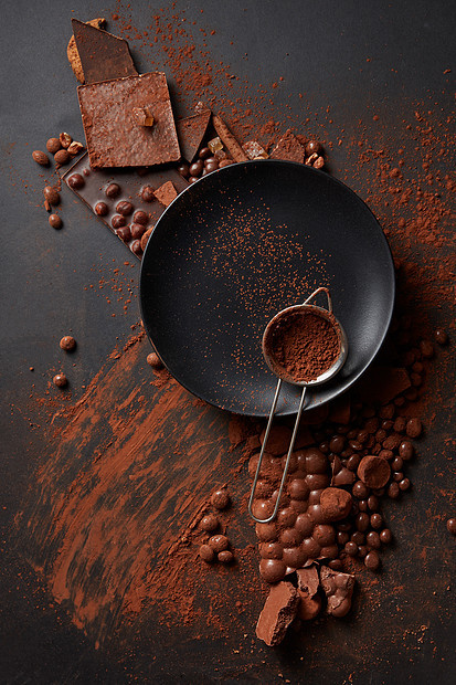 可可粉个筛子上的黑色盘子,黑色背景与巧克力巧克力可可粉图片