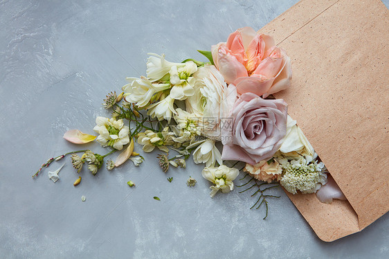 灰色背景上以信封表示的花的成情人节男子送女子花玫瑰同的花假日灰色背景下的花朵成图片