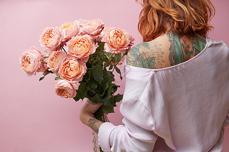 女孩背上纹身,着大粉红色玫瑰媒体粉红色的背景,后看情人节,母亲节着大粉红色玫瑰的女孩图片