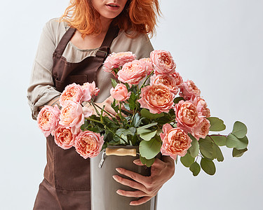 一束鲜花美丽明亮的花个女人着个粉红色玫瑰的花瓶母亲节花店的女人着个花瓶新鲜的粉红色玫瑰背景