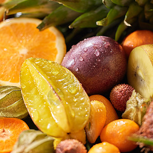 夏季异国水果背景与新鲜多汁的成分杨桃,橙色,猕猴桃,金橘,西番莲健康饮食的特写热带背景与新鲜的黑皮水果杨桃,西番图片