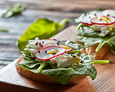 清淡健康的三明治,包烤包,柔软的奶酪新鲜采摘的机萝卜,木板上的菠菜特写镜头意大利番茄自制的Bruschetta与图片