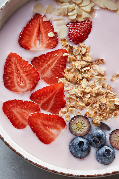 饮食自制的天然早餐与新鲜的机成分浆果,麦片,坚果牛奶陶瓷碗灰色的桌子上的风景健康饮食的自制的麦片盘图片