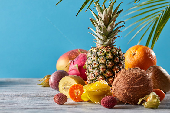 芒果,火龙果,西番莲,椰子,菠萝,杨桃,金橘蓝色背景上群异国情调的热带水果素食健康创造的异国情调成图片