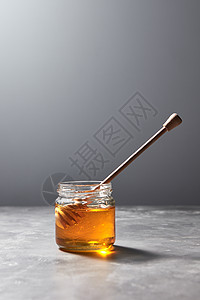 甜葵天然蜂蜜罐子木勺上灰色大理石桌子,犹太罗什哈沙纳假日芳香新鲜的天然蜂蜜与迪珀璃锅上的灰色石桌,纯天图片