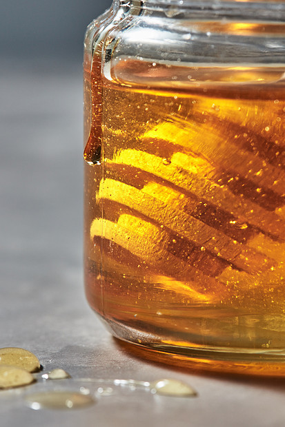 蜂蜜背景与天然花黄色蜂蜜璃罐与木制北斗七星,传统的纯天然甜善近距离观看璃罐与金色蜂蜜木制北斗七星灰色背景犹太新图片