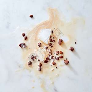 咖啡牛奶,冰块,巧克力咖啡豆的碎片灰色大理石背景上,食物模式平躺种咖啡的飞溅模式,灰色大理石背景图片