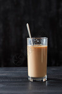 新鲜咖啡与牛奶璃与金属勺子黑色木桌上与美味的咖啡与牛奶璃与勺子黑色木桌上与图片