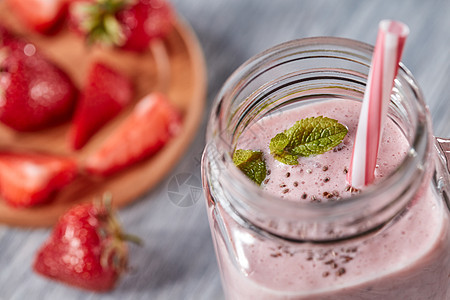 自制草莓奶昔与CHIA种子绿色薄荷叶个罐子与个小管个木制的背景机维生素甜点的风景机牛奶草莓冰沙图片