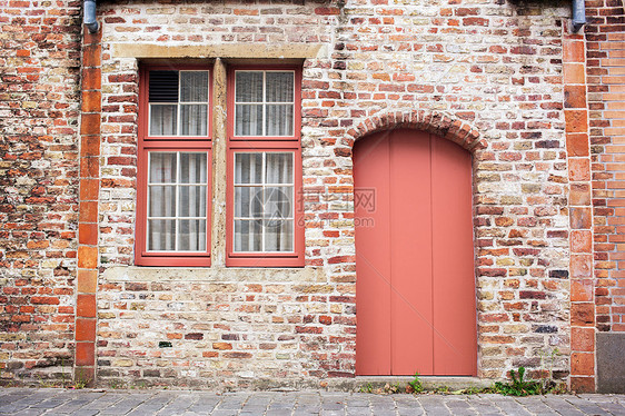 新油漆的门旧的欧洲石头房子布鲁日,比利时,2019的颜色活珊瑚潘通立砖旧墙与彩绘门个流行的颜色2019活珊瑚潘通图片