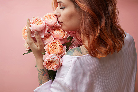 美丽的女孩与芬芳的花个背景上的时尚颜色的2019活珊瑚潘通母亲节情人节贺卡个纹身的女孩着花玫瑰,背景柔图片