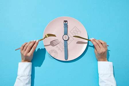 白色盘子Whatch与蓝色带六个ORsquo时钟服务刀叉个女孩的手个蓝色的背景,文本时候吃饮食了图片