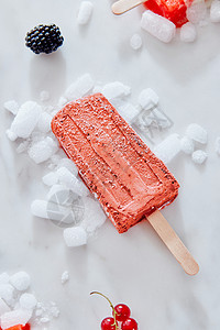 自制冰棒蓝莓奶油的颜色2019活珊瑚潘通碎冰上的大理石背景与浆果,顶部视图夏天的浆果黑色醋栗冰淇淋冰棒201图片